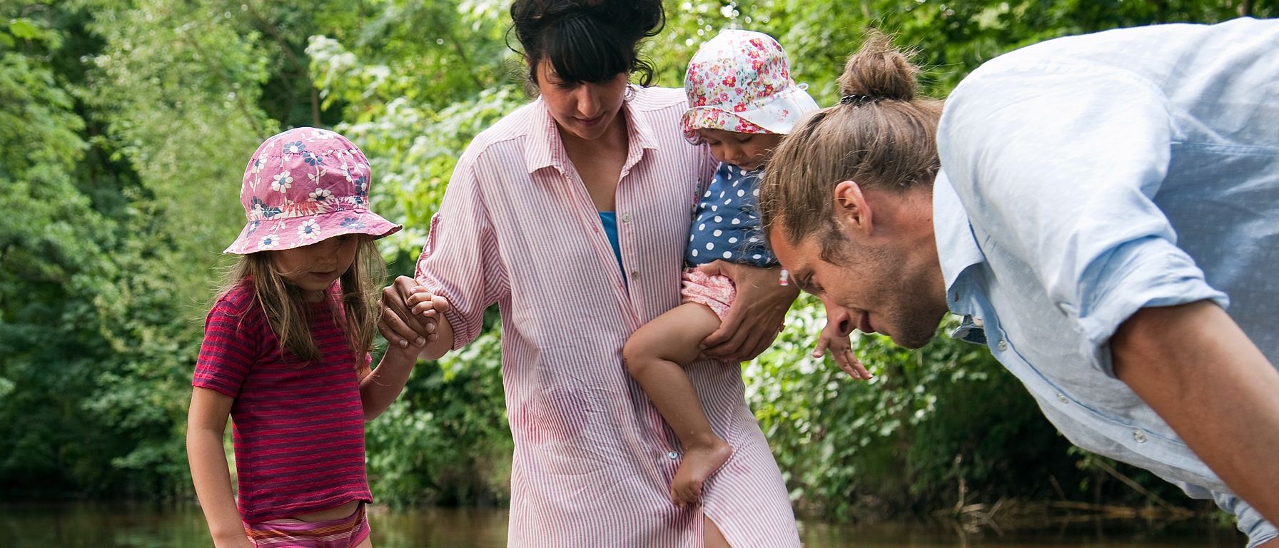 youg family standing in creek
