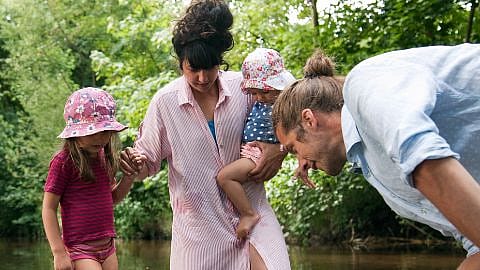 youg family standing in creek
