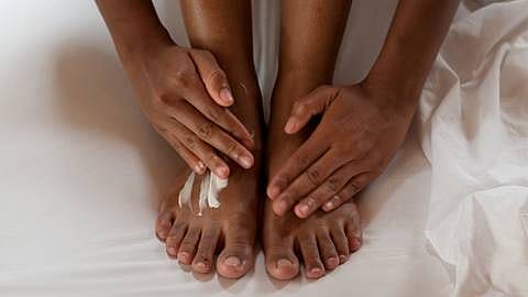 Woman creaming her feet