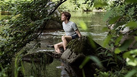 man sitting at river