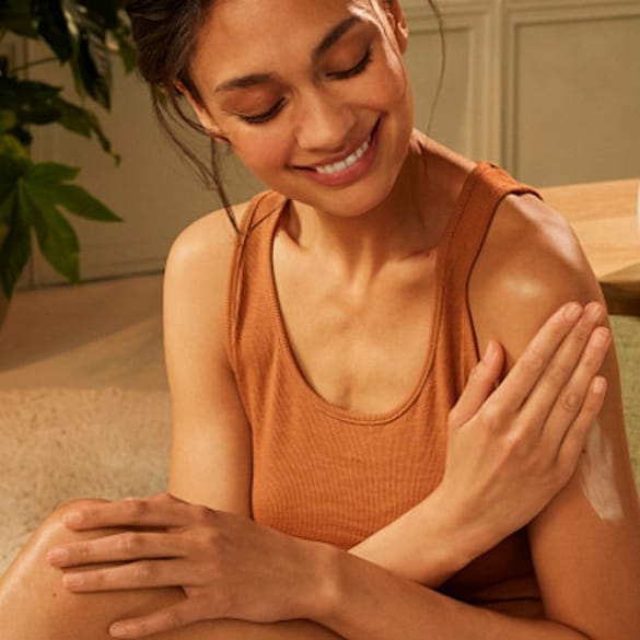 Woman creaming arm